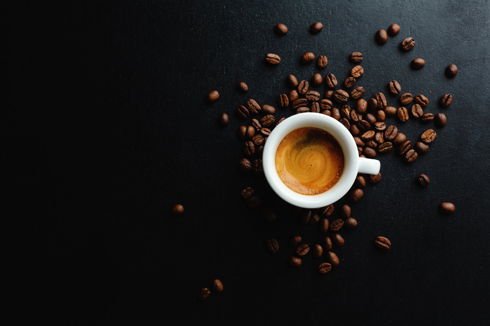 Due persone che brindano con una tazza di caffè nero e un cappuccino